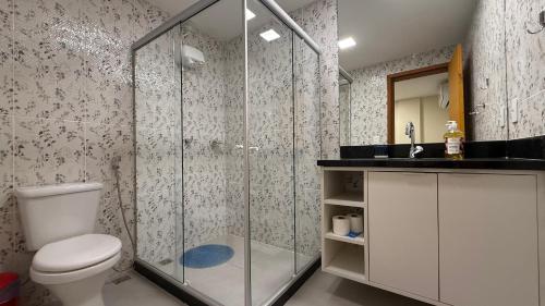 a bathroom with a toilet and a glass shower at Caminho de Itacoatiara in Niterói
