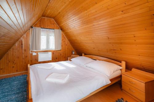 a bedroom with a bed in a wooden room at Chata Jánošík in Terchová