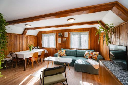 a living room with a green couch and a table at Chata Jánošík in Terchová