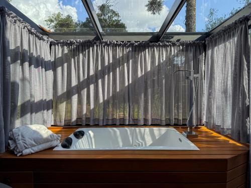 a bathroom with a bath tub in front of a window at Studios Heaven in Gramado