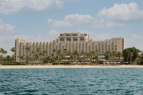 a large building on the beach next to the ocean at JA Beach Hotel, Dubai in Dubai