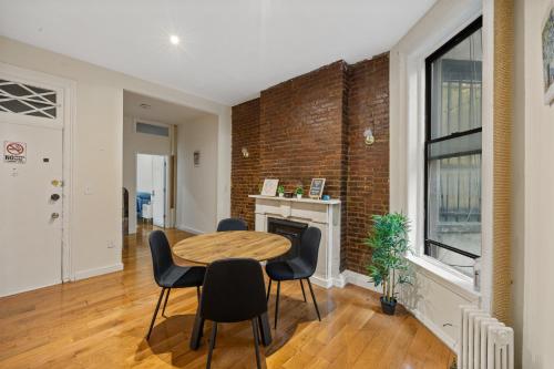a dining room with a brick wall and a table and chairs at Steps from Times Square - Cozy Room - Shared Bath in New York