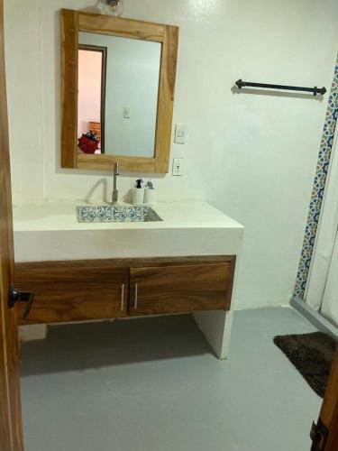 a bathroom with a sink and a mirror at Cabaña CasaMar Angelica in El Puertón