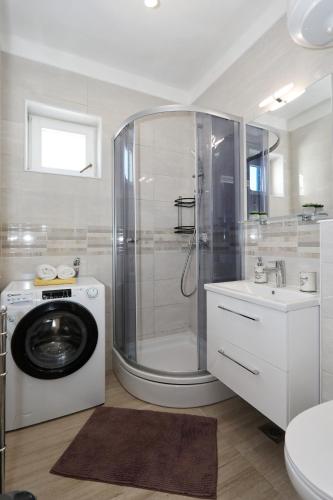 a bathroom with a shower and a washing machine at Apartment Tea with Sea View in Petrcane