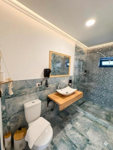 a bathroom with a toilet and a sink at Delta Land Bungalows in Crisan