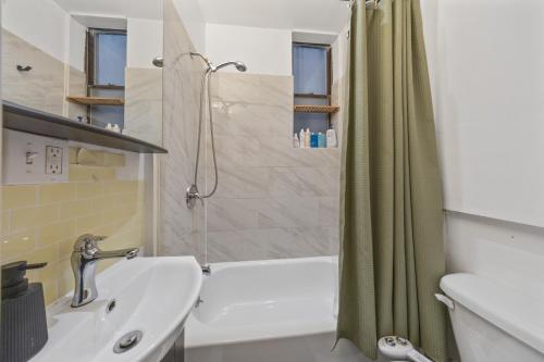 a bathroom with a shower and a sink and a tub at Private Room at a Shared Apartment by Times Square in New York