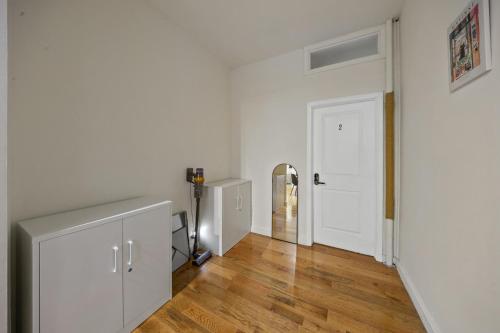 a hallway with white walls and wooden floors and a white door at Private Room at a Shared Apartment by Times Square in New York