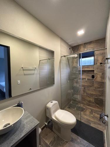 a bathroom with a toilet and a sink and a shower at Dalusa House in Tena