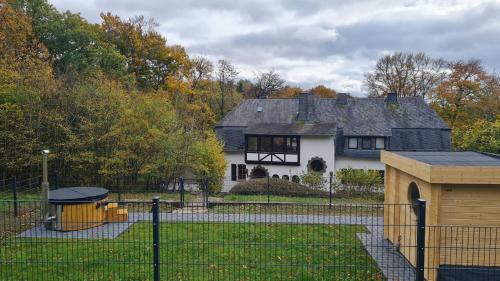 a white house with a fence in front of it at Landhaus Karbach mit Gartensauna und Hot Tub, eingezäunter Garten, 4-10 Personen in Mayen