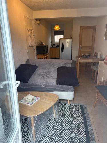 a living room with a bed and a table at La maisonnette LMV in Sanary-sur-Mer