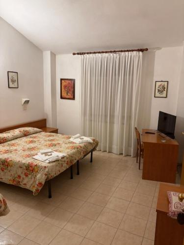 a bedroom with a bed and a desk and a television at Osteria dei Locandieri in Abbadia San Salvatore