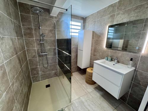 a bathroom with a shower and a toilet and a sink at Appartement Mango in Rivière-Salée