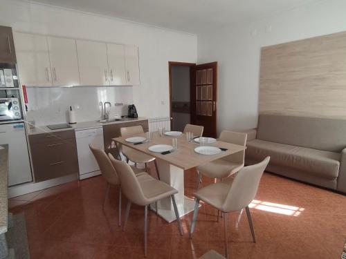 a kitchen and a dining room with a table and chairs at Quinta Cunha in São Pedro do Sul