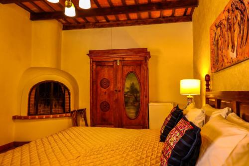 a bedroom with a bed and a wooden cabinet at Villa de Antaño in Antigua Guatemala