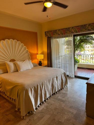 a bedroom with a large bed with a fan on it at Perfect Place Velas Vallarta Resort in Puerto Vallarta