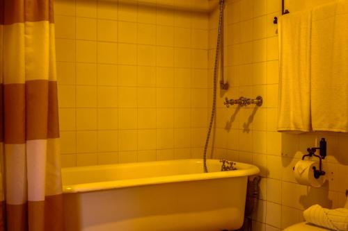a bathroom with a yellow bath tub and a toilet at Villa de Antaño in Antigua Guatemala