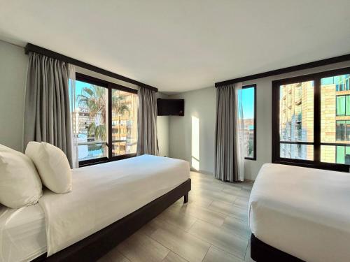 a hotel room with two beds and large windows at Hotel Tempo Rent in Santiago