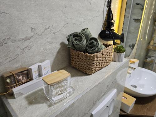 a bathroom with a basket of towels and a sink at ENA Lux in Novi Pazar