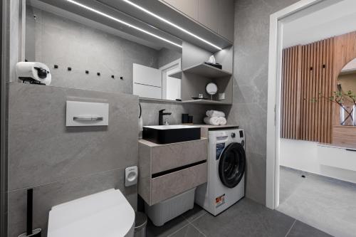 a bathroom with a washing machine and a sink at Sunshine Breeze in Promajna