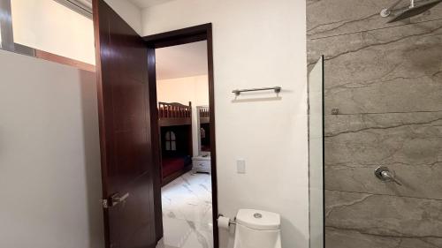 a bathroom with a toilet and a glass shower door at Villa 1 TRES SENDEROS in Omitlán de Juárez