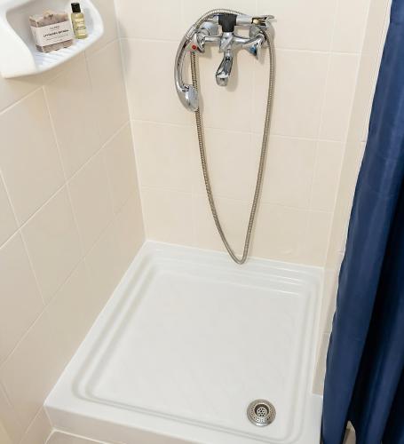 a shower with a shower head in a bathroom at Villa Estrella - Pool - Sunset Views - 200m Siviri Beach in Siviri