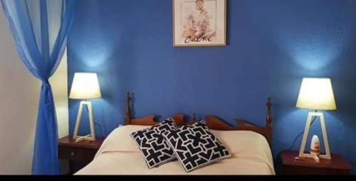 a bedroom with blue walls and a bed with two lamps at San bernardo edificio frente al mar in San Bernardo