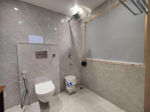 a bathroom with a toilet and a shower stall at Nirvana Bliss By Cosy Homes, Malsi in Dehradun