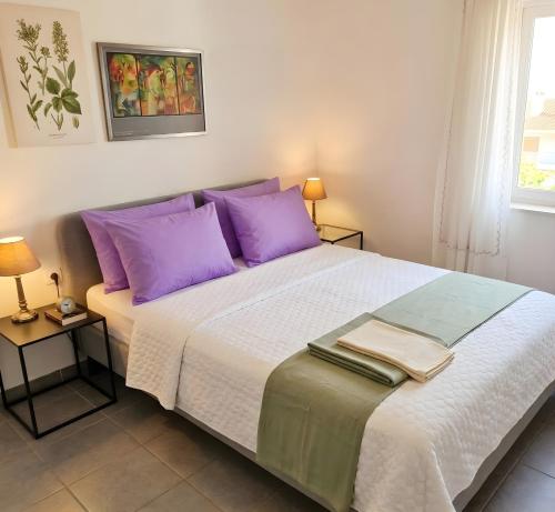 a bedroom with a large bed with purple pillows at Villa Estrella - Pool - Sunset Views - 200m Siviri Beach in Siviri