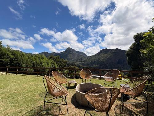 a group of chairs sitting next to a fire pit at Casa 04 Monte Boa Vista - Conforto com Piscina Privativa, Sauna e Lareira in Teresópolis