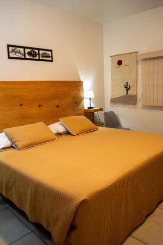 a bedroom with a large bed with yellow sheets at Casa Nieto in Teotitlán del Camino