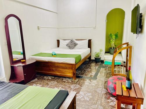 a bedroom with a bed and a mirror and a table at Kandy Green HillTop Hotel in Kandy