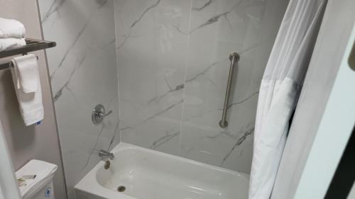 a bathroom with a shower and a white tub at Days Inn by Wyndham Paducah I-24 Exit 4 in Paducah