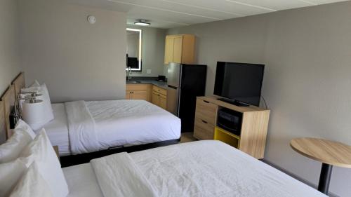 a hotel room with two beds and a flat screen tv at Days Inn by Wyndham Paducah I-24 Exit 4 in Paducah