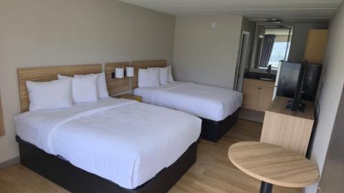 a hotel room with two beds and a flat screen tv at Days Inn by Wyndham Paducah I-24 Exit 4 in Paducah