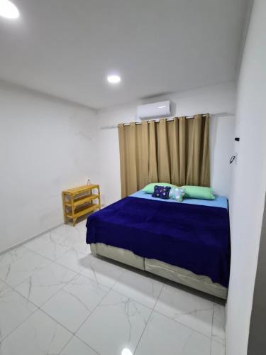 ein Schlafzimmer mit einem blauen Bett in einem weißen Zimmer in der Unterkunft Casa Riso Dourado in Paracuru