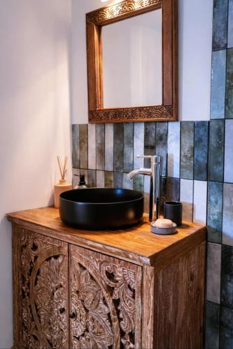 a bathroom with a black sink and a mirror at Aimeho Bungalow in Paopao