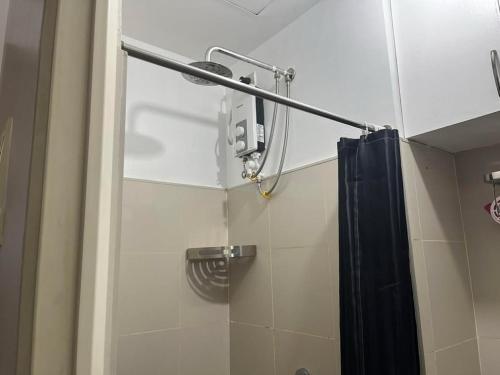 a shower with a black shower curtain in a bathroom at MDM Staycation by SMDC in Manila