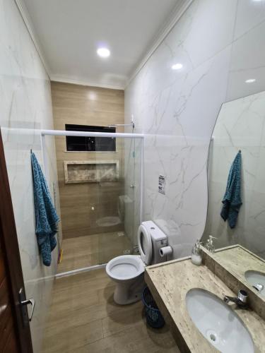 ein Badezimmer mit Toilette, Waschbecken und Spiegel in der Unterkunft Casa Riso Dourado in Paracuru
