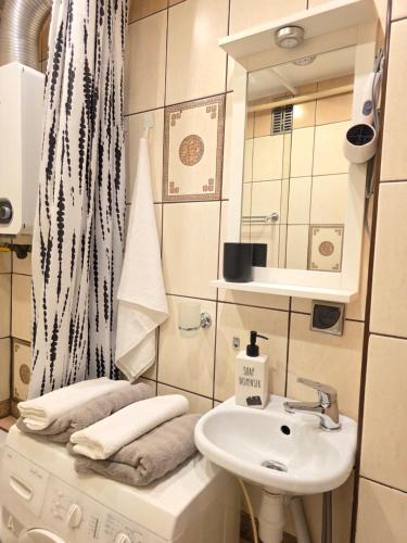 a bathroom with a sink and a mirror and a sink at GreatHome Apartament in Zator