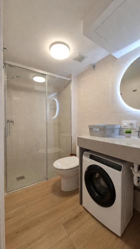 a bathroom with a toilet and a washing machine at Apartamento Estartit Argonavis in L'Estartit