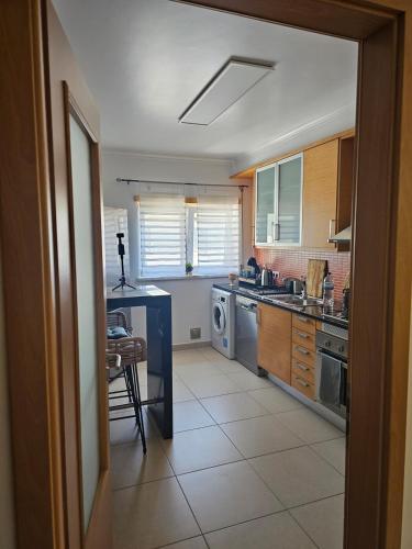a kitchen with a sink and a dishwasher at Brisa do Mar in Leiria