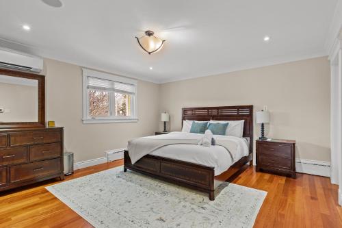 a bedroom with a bed and a dresser and a mirror at Forest House QV Lake View Parking in St. John's