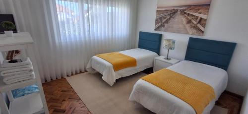 a small room with two beds and a window at Ribeiro´s House in Gafanha da Nazaré