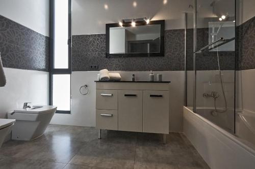 a bathroom with a sink and a toilet and a shower at Can Anara in Cala Llena
