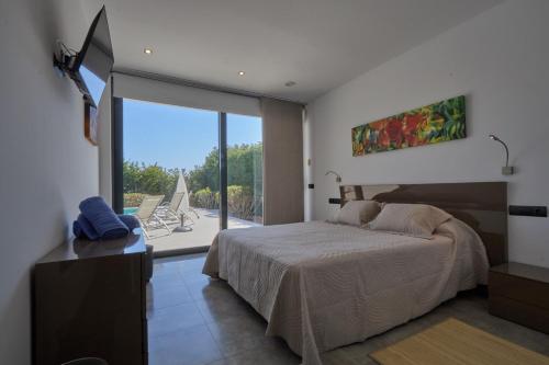 a bedroom with a bed and a view of a balcony at Can Anara in Cala Llena