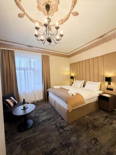 a bedroom with a large bed and a chandelier at Hotel Fatima in Trenčín