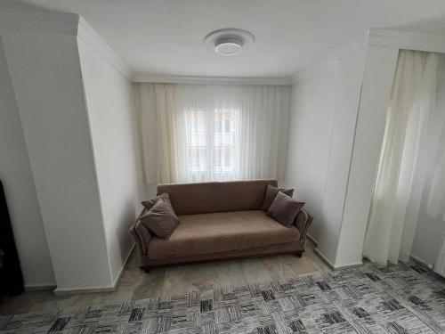 a couch sitting in a room with a window at BR Konaklama in Göztepe