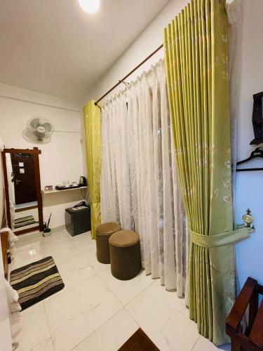a living room with yellow and green curtains at Rich Grove Inn in Ella