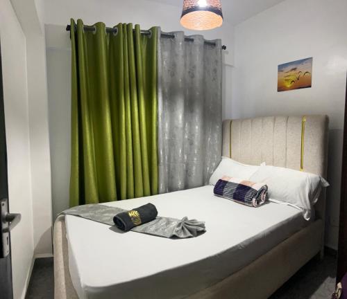 a bedroom with a bed with a green curtain at Gated executive 1 bed in gated near Top Malls, Kisumu in Kisumu
