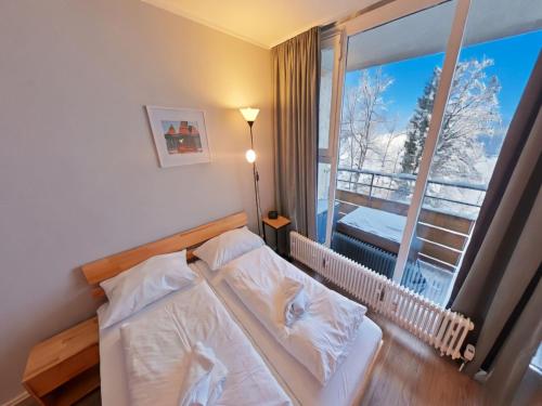 a bedroom with a bed and a large window at Appartement Serges mit Pool und Sauna in Freyung in Freyung